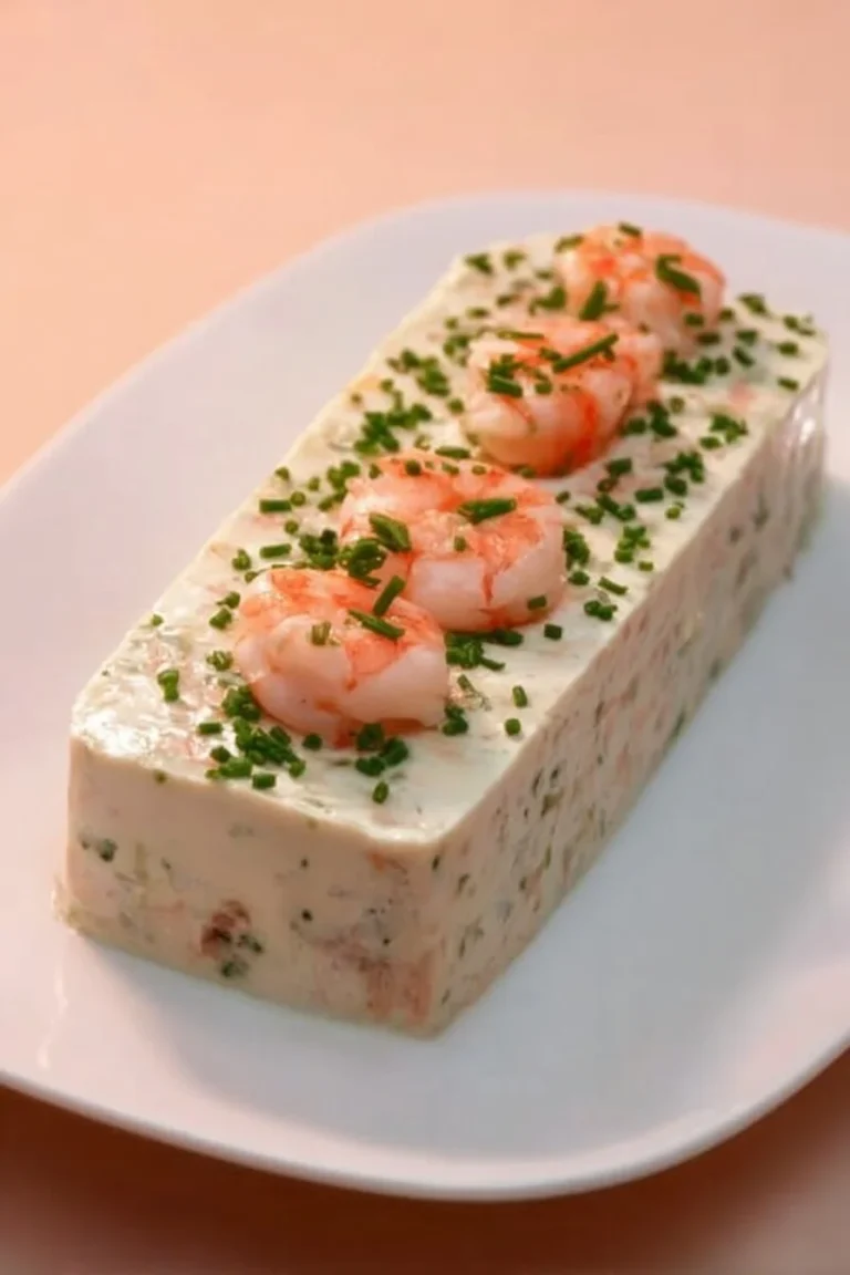 Terrine de poisson servie en entrée, avec garnitures colorées et accompagnements.