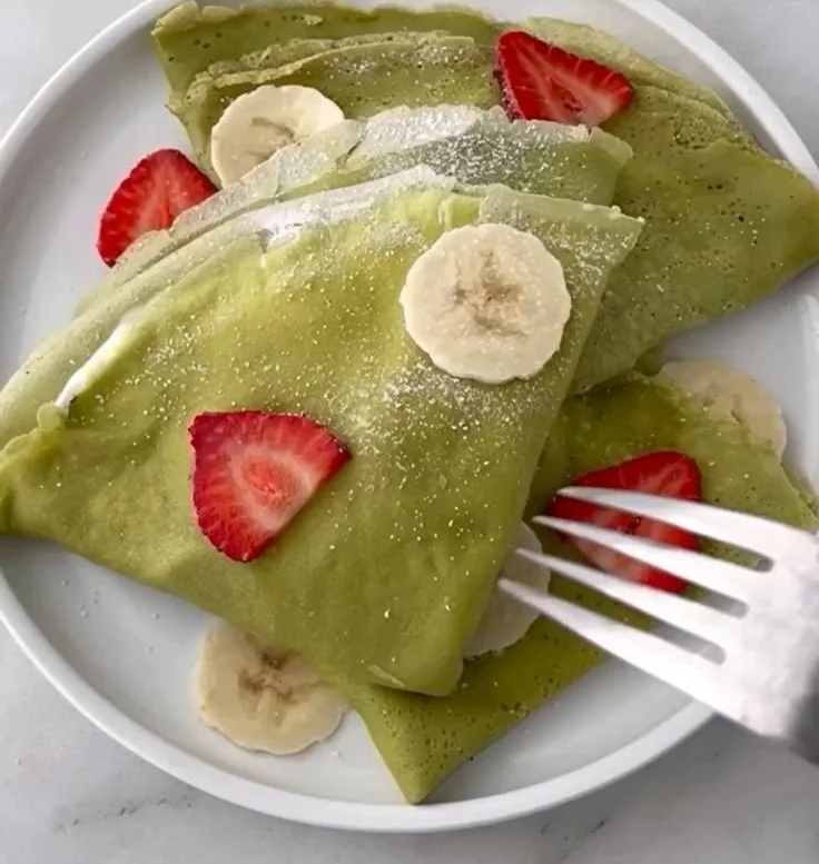 Crêpes au matcha servies avec des fruits et de la crème