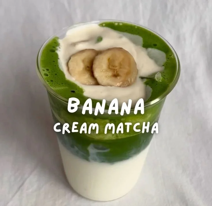 Latté matcha crémeux avec crème de banane dans un verre élégant.