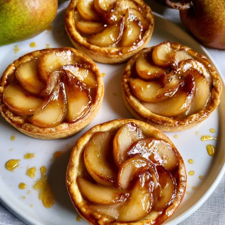Tarte aux poires caramélisées dorée et appétissante sur une assiette.